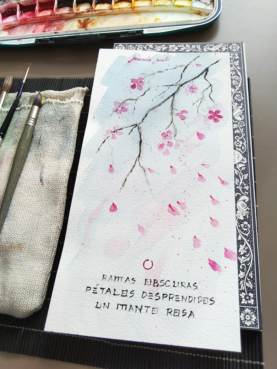 Vista completa en ángulo del haiku “Adiós primavera” acompañado de la ilustración en acuarela de una rama de almendro. Vista con luz natural.