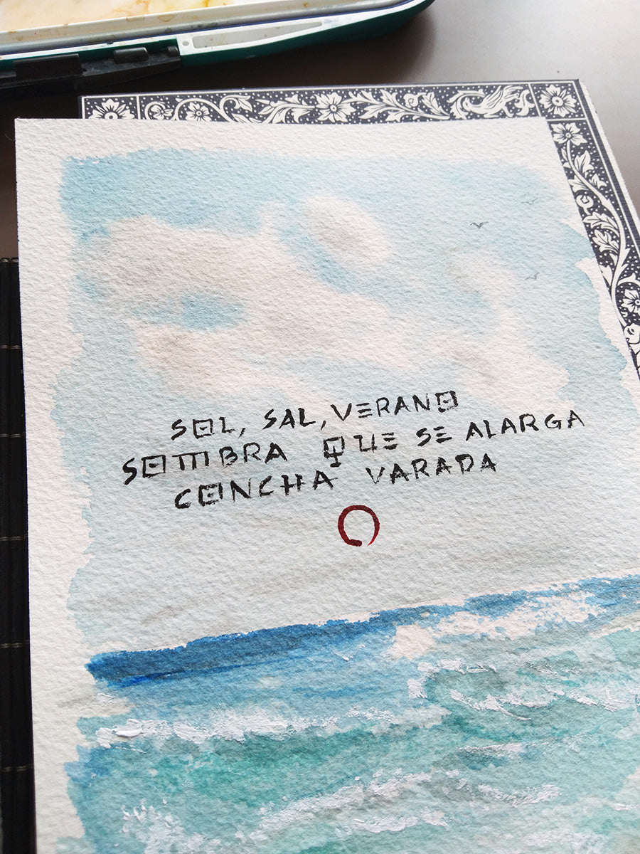 Primer plano del haiku en acuarela, mostrando su textura natural y los reflejos de luz sobre la arena