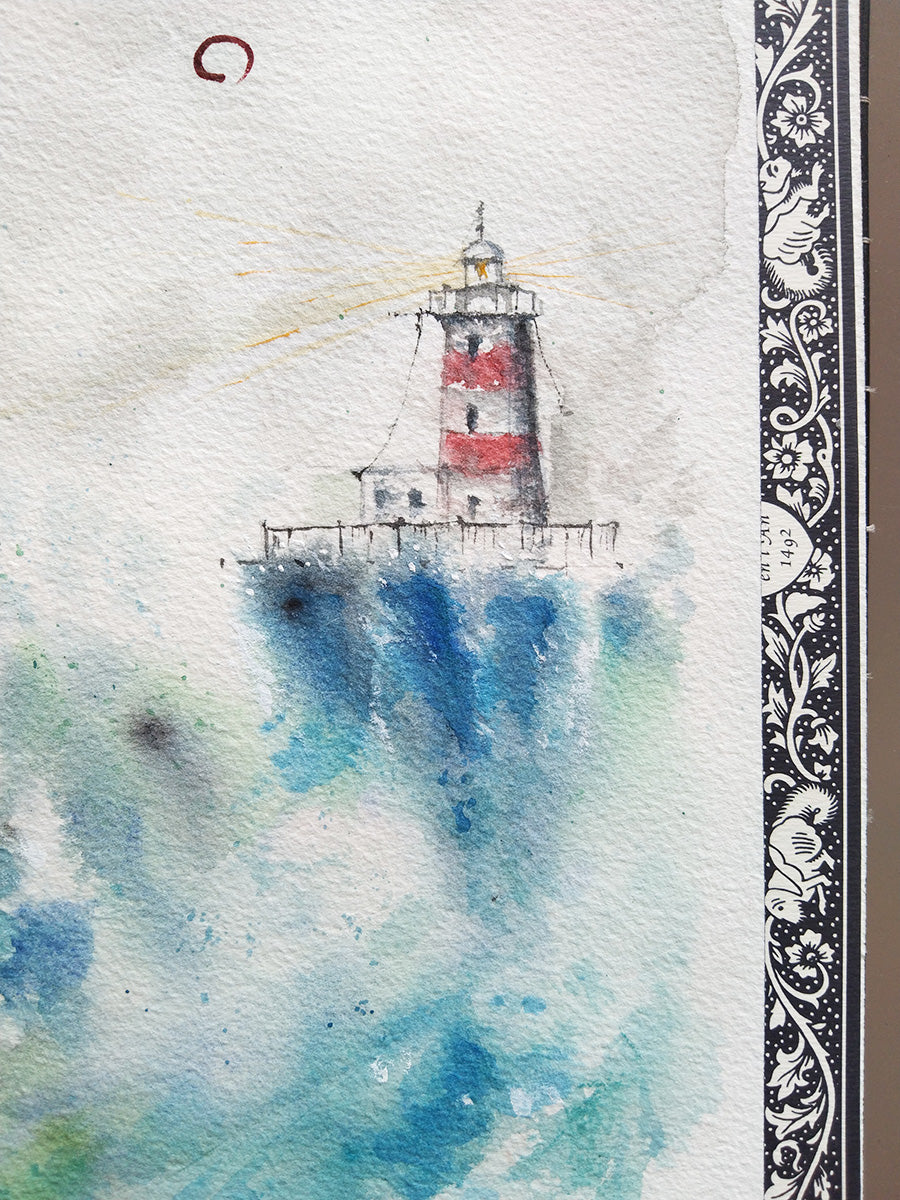 Detalle del faro rojo y blanco en la haiga Marina I, con olas azules y espuma en primer plano.